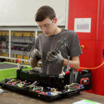 A male employee assembles a piece of machinery at MM Technics in the Central SC Region