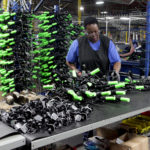 A female employee examines dozens of parts at the Bicycle Corporation of America facility in the Central SC Region