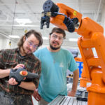 Two male students from Piedmont Tech operating a manufacturing device in the Central SC Region
